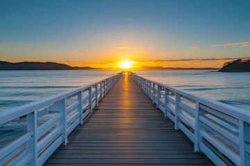 Naklejka premium A serene pier extending into the ocean at sunset, creating a tranquil and picturesque scene.