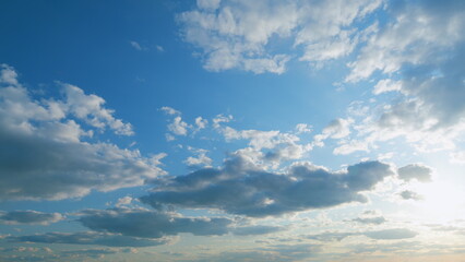 Fototapeta premium Beautiful blue sky cloudy behind shining sun rays and eventually breaking through cloud mass. Timelapse.