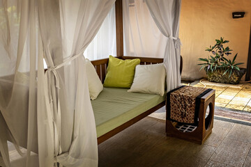Private guest area in luxury hotel with sun bed, white curtains and bed table