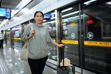 Woman with Suitcase Waiting at Metro Station for Transit