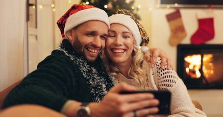 Christmas, happy and selfie of couple in home take photo for profile picture, social media post and memory. Love, bonding and man and woman hug on sofa for festive tradition, holiday and vacation