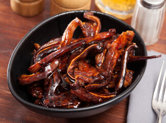 Appetizing Korean pork ears served in black bowl