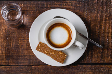 cafe macchiato coffee in white porcelain cup on wooden table