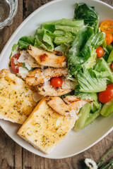 Caesar salad served in white plate on table