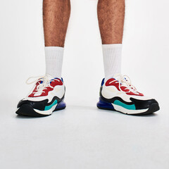 Closeup, sneakers and man with sports, legs and model on white studio background. Person, athlete...
