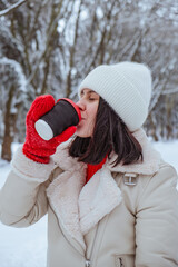 happy woman with coffee cup outdoors at winter cold day