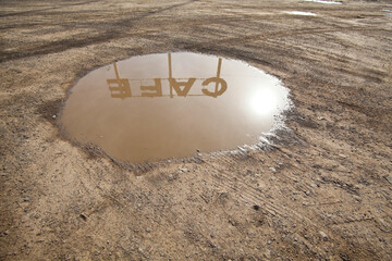 Reflection of a cafe sign in a puddle outside Ritzville in Washington state. 