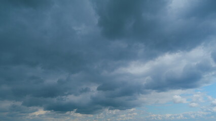 Fototapeta premium Sky with white fluffy rain clouds on the blue sky. Dramatic cloudscape, amazing sky. Time lapse.