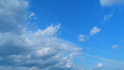 Dramatic moving white cumulus and cirrocumulus clouds or puffy fluffy cloudscape on beautiful sunny...