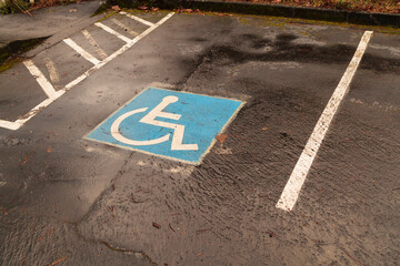 High angle close up of a parking space for wheelchair users, road marking, blue sign,