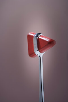 Close up of a red reflex hammer with a pointed end