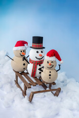 A joyful snowman and two sandy snowmen pose together for a Christmas and New Year celebration on a...