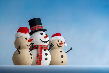 A joyful snowman and two sandy snowmen pose together for a Christmas and New Year celebration! This mix of winter and beach vibes brings a fresh holiday twist.