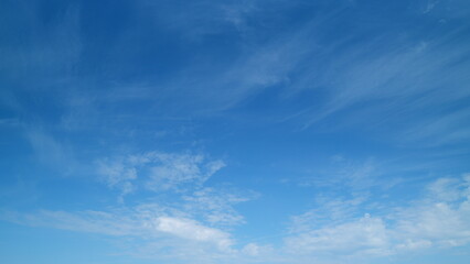 Fototapeta premium Fluffy layered clouds sky atmosphere. Majestic amazing blue sky with clouds. White and blue colors. Timelapse.