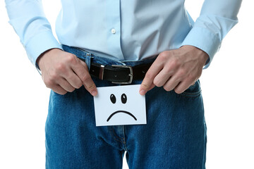 STD (sexually transmitted diseases). Man holding sticky note with drawn sad face on white...