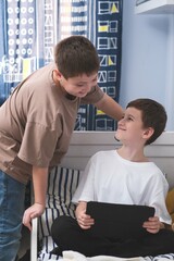 Fototapeta premium Boys enjoy various tablet activities together in a cozy bedroom, having a great time
