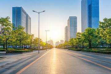 Obraz premium A serene urban landscape at sunset, showcasing modern buildings and greenery along a wide street.