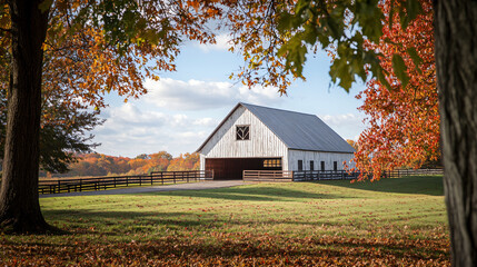 Obraz premium A classic barn framed by the colors of fall, creating a picturesque setting for Thanksgiving celebrations.