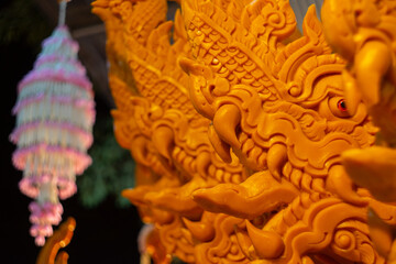 Fototapeta premium NAKHONRATCHASIMA, THAILAND - JULY 11: Candle wax carving Thai style texture in the traditional parade active festival Buddhist Lent on JULY 11, 2019 in Nakhon Ratchasima, Thailand.