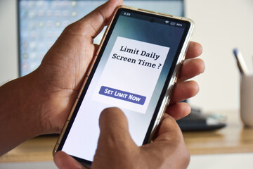 Man setting up screen time limit on his mobile phone. Digital wellbeing concept, selective focus.