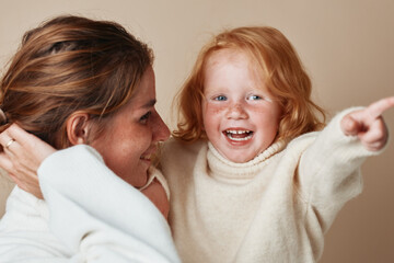 Mother and daughter pointing at camera together during family vacation travel adventure