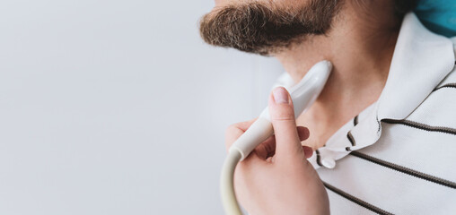 banner close-up doctor doing thyroid ultrasound to man, ultrasound sensor in hand