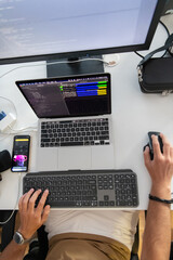 Top view of programmer diligently testing smartphone applications while sitting in their office.