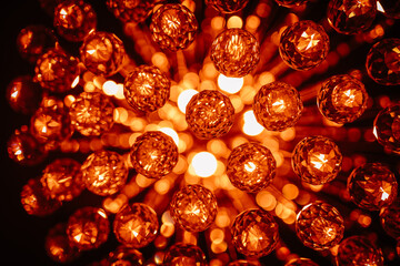 A close-up of orange crystal spheres in a chandelier, creating a warm, glowing ambiance with...