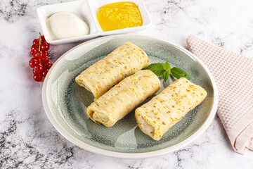 Homemade stuffed pancakes with honey and cream sour