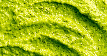 Green yogurt ice cream with pistachios, kiwi and avocado. Fresh fruit smoothie. Ice cream texture. Delicious sweet dessert close-up as background.