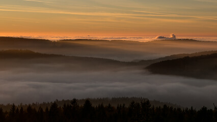 Sunset in the Teplice-Adršpašské rocks. The sun is low on the horizon and the inverted clouds create stunning scenery that makes it seem as if you are above the clouds.