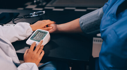 A doctor taking a patient's blood pressure. The patient's arm is equipped with a blood pressure cuff, and the doctor is using a blood pressure monitor.