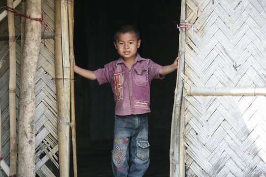 Bangladeshi tribal kid standing in doorway 