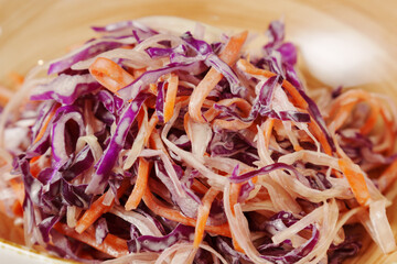 This colorful coleslaw showcases finely shredded purple and orange cabbage, creating a crunchy,...
