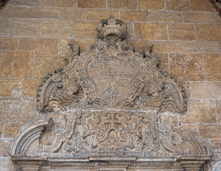 Antiguo escudo en piedra sobre la puerta de entrada a la sala capitular de la catedral de Oviedo, España