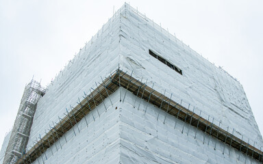 Large Building Restoration Surrounded By Scaffolding And Sheeting