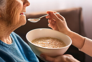 老人に食事を食べさせる人の手元
