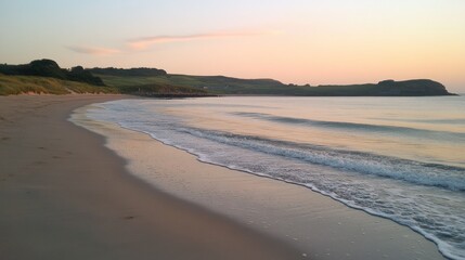 Fototapeta premium A serene beach at sunrise, gentle waves lapping the shore 