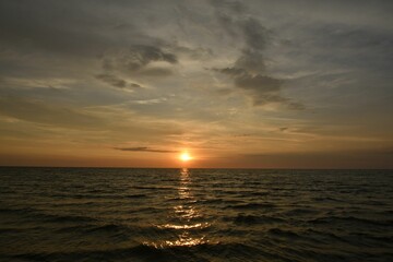Serene ocean sunset with golden hues.