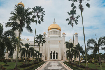 Majestic Sultan Omar Ali Saifuddien Mosque in Brunei with gold domes and lush palm trees