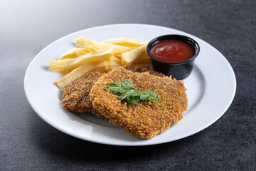 Cachopo, Traditional food in Asturias, Spain. Breaded fillet meat on black slate background