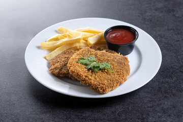 Cachopo, Traditional food in Asturias, Spain. Breaded fillet meat on black slate background