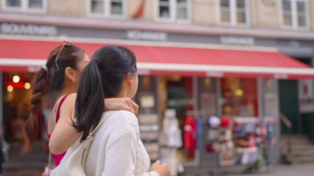 Asian two woman holding shopping bags and walking at outdoors marketplace. 