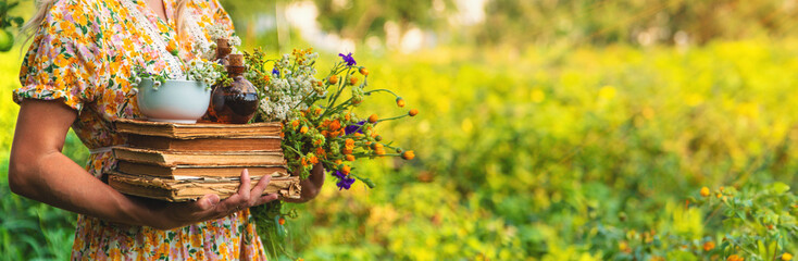 Woman with medicinal herbs in a meadow. Selective focus.