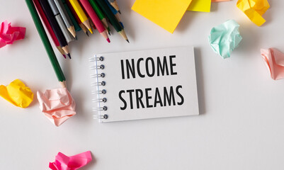 Income Streams Text Written on the White Background With Paper Sheet and Colour Pencils