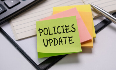 Policies Update Memo Written on a Notebook With Pen, Calculator and Book.