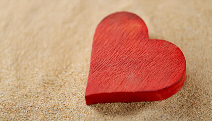 Fototapeta premium Handmade wooden heart on sand surface.