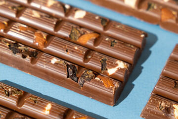 Lots of chocolate bars with nuts and raisins on a blue background