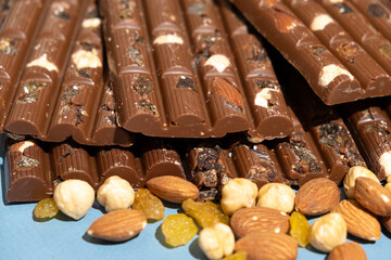 Lots of chocolate bars with nuts and raisins on a blue background