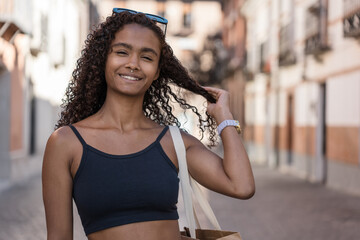 Beautiful young woman is touching her hair and smiling